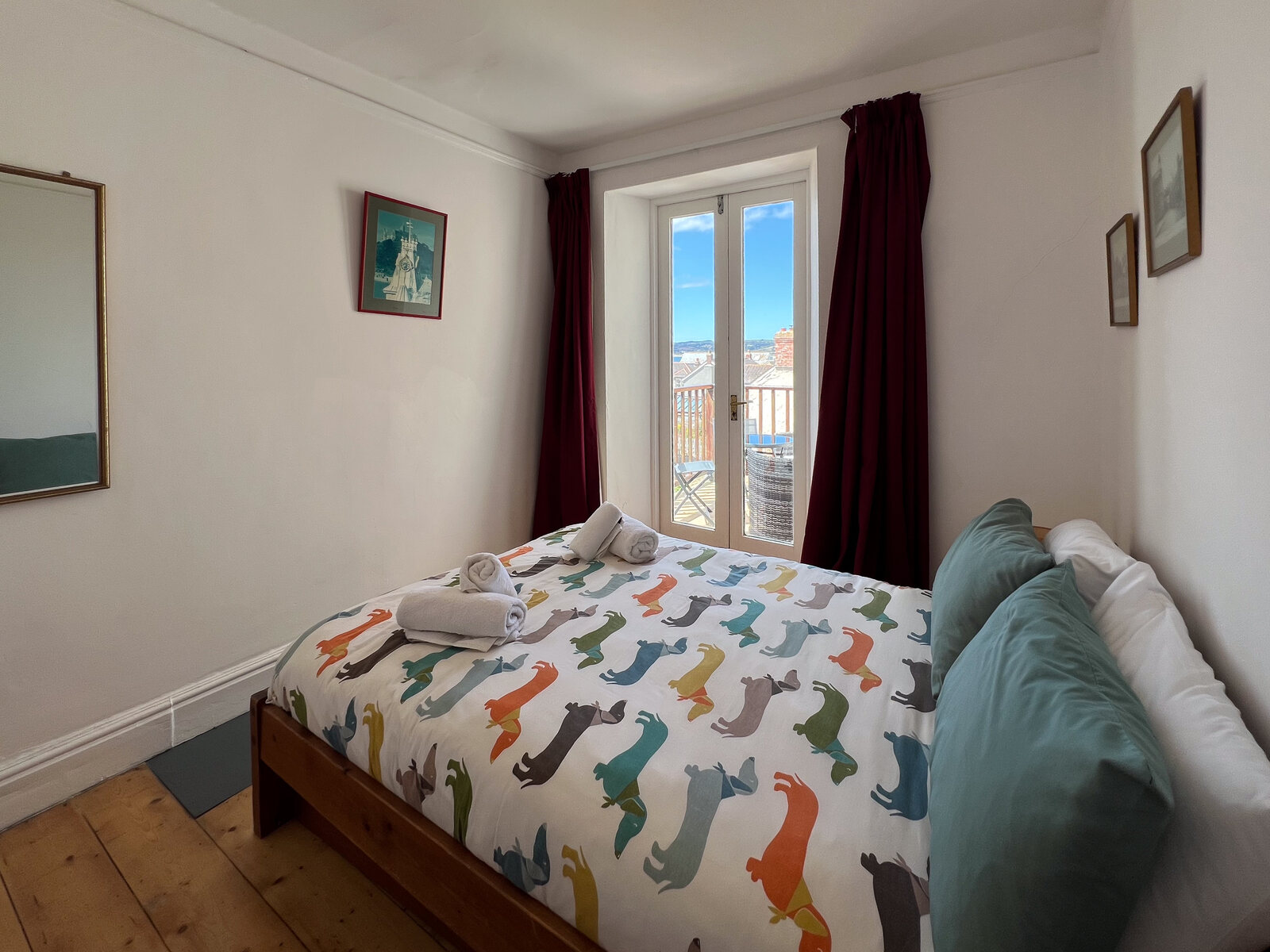 Double bedroom with playful bedding and green cushions