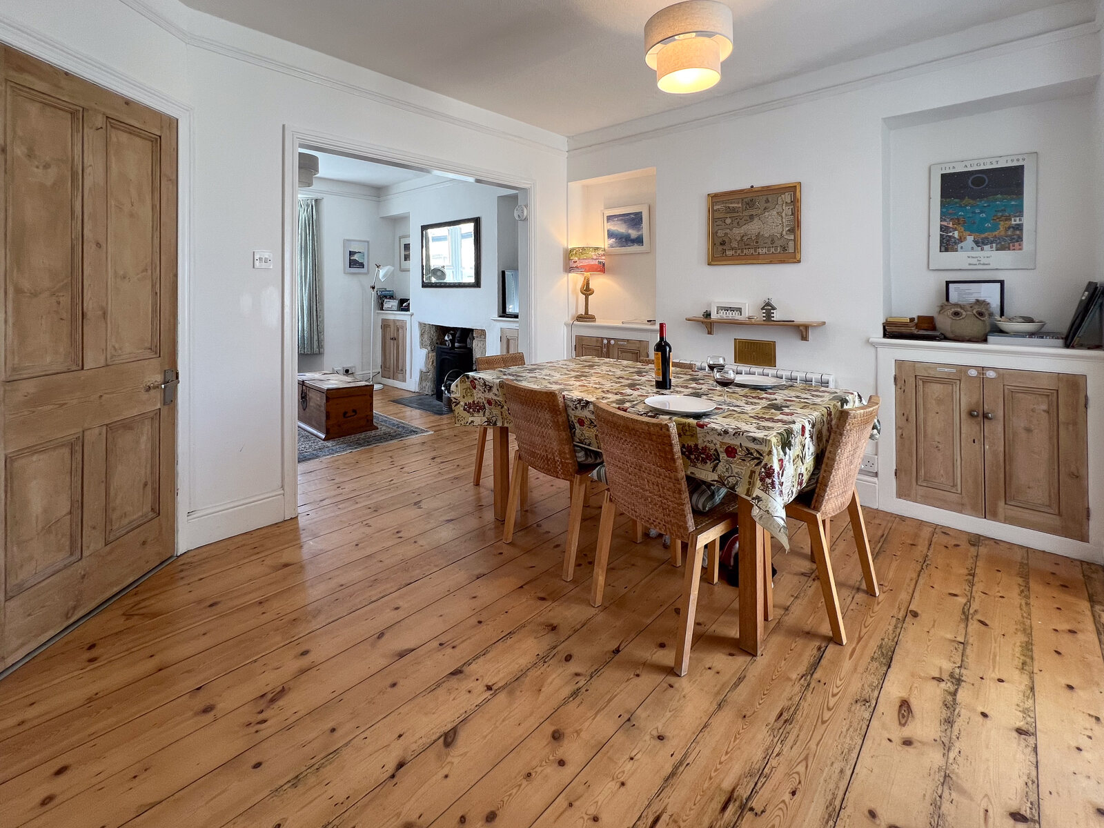 Dining room with a laid table opening through the cottage