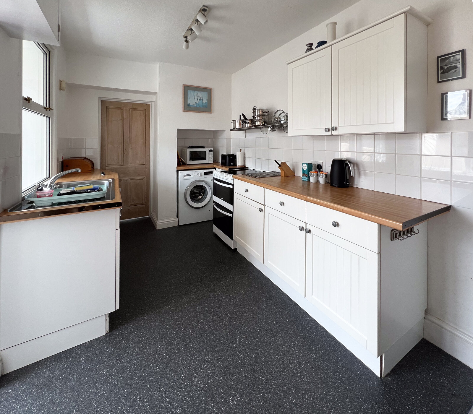 Well-equipped kitchen with cream units and wood worktops