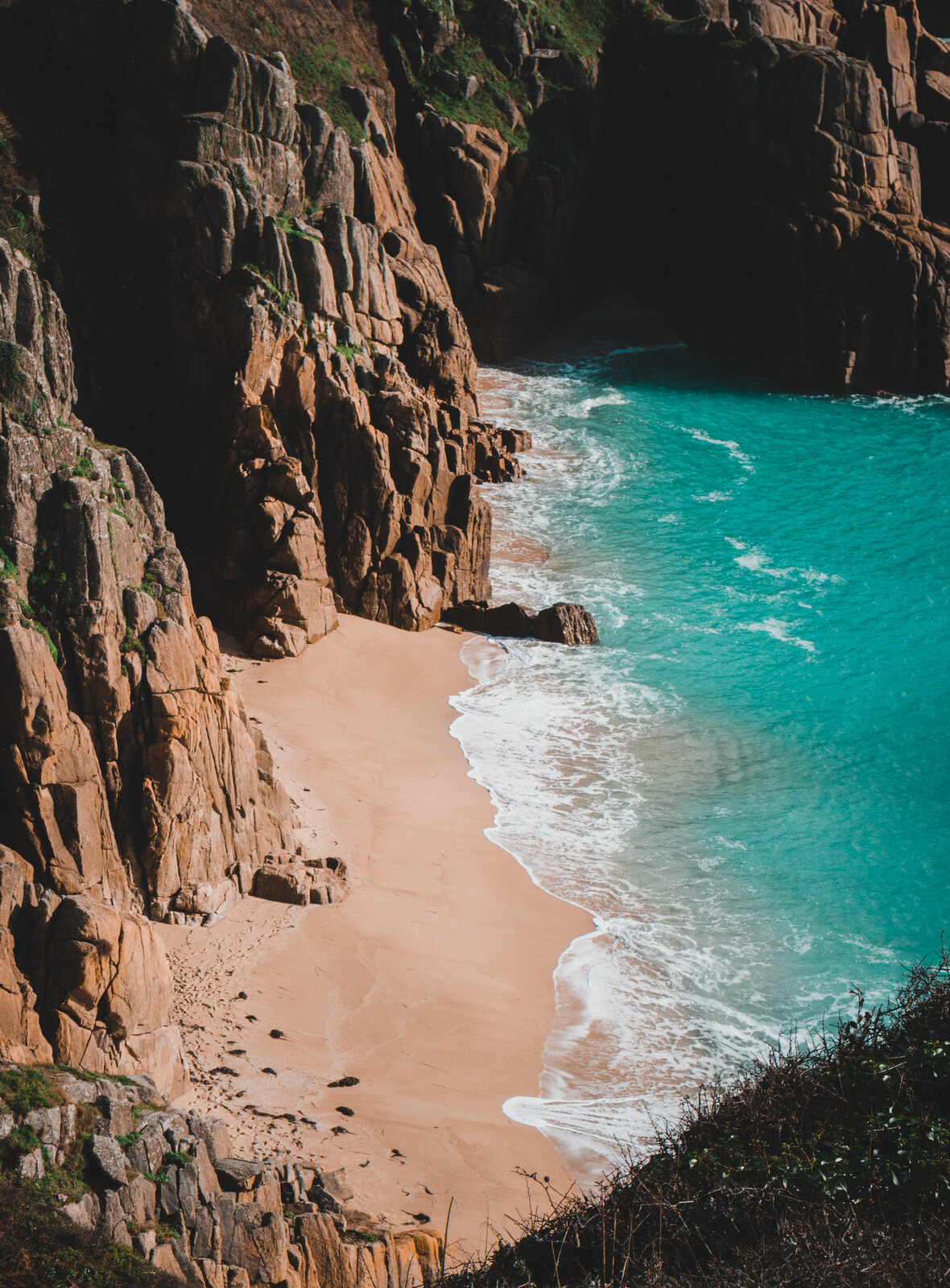 Turquoise water and golden sand at a sheltered cove below granite cliffs