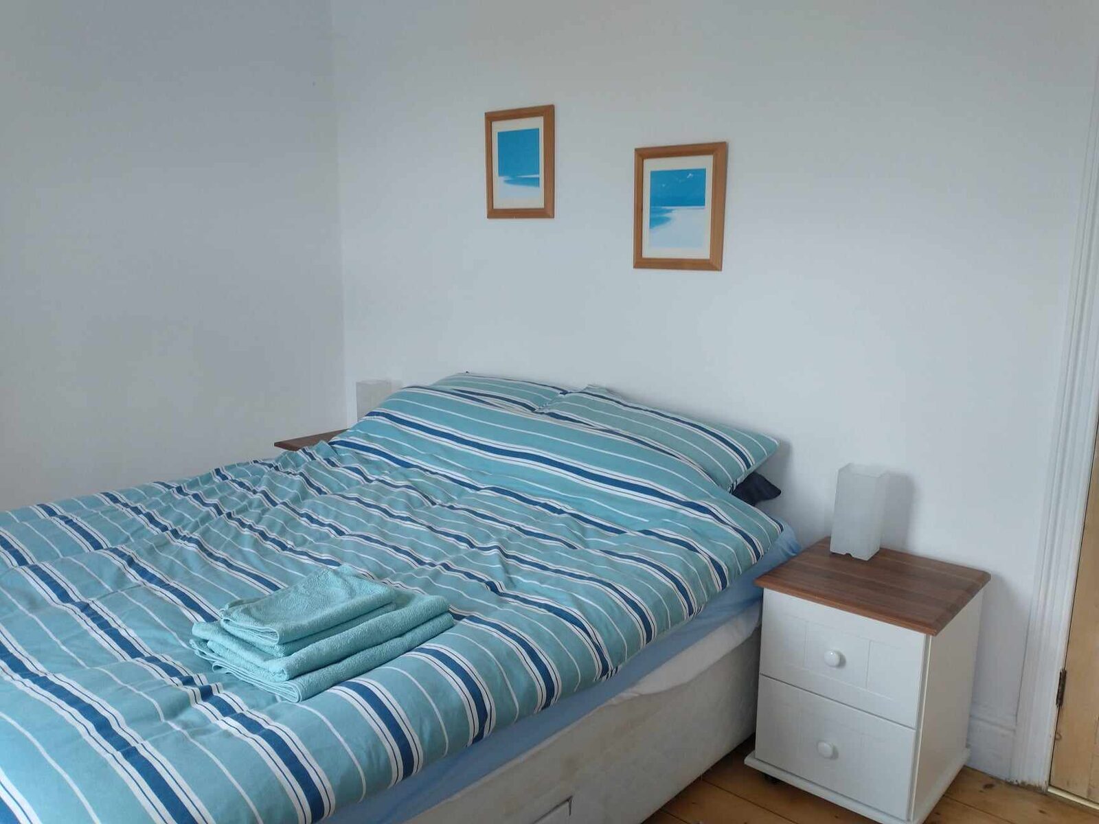 Restful double bedroom with seaside prints