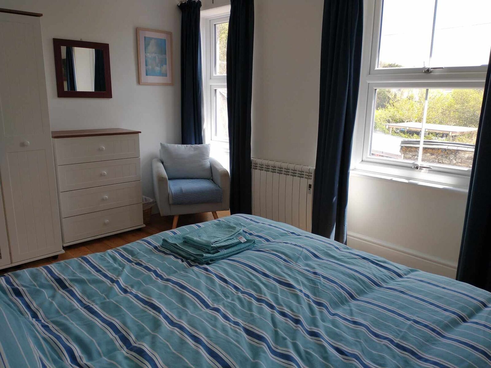 Double bedroom with armchair and bright windows
