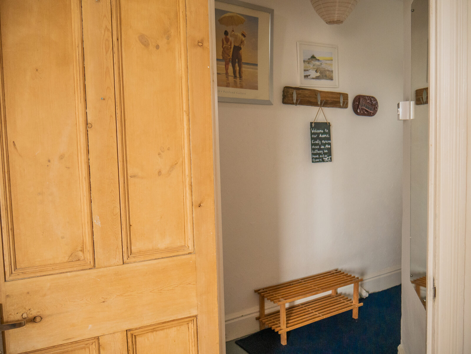 Welcoming hallway with pine doors and coastal artwork