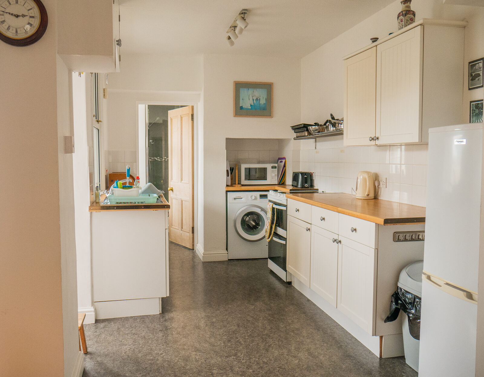 Well-equipped kitchen with cream units and fresh flowers