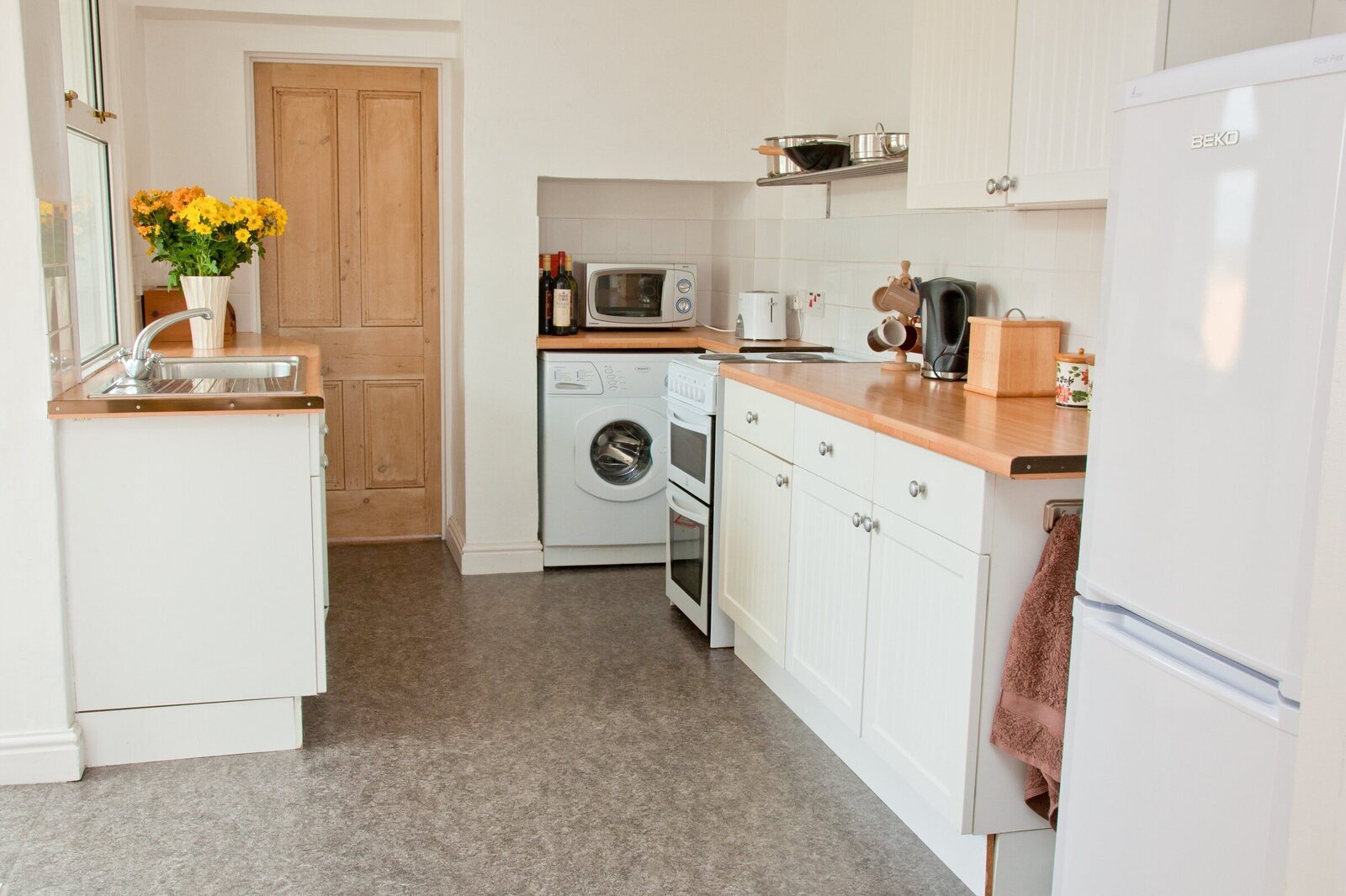 Kitchen with oven, washing machine and full-size fridge freezer