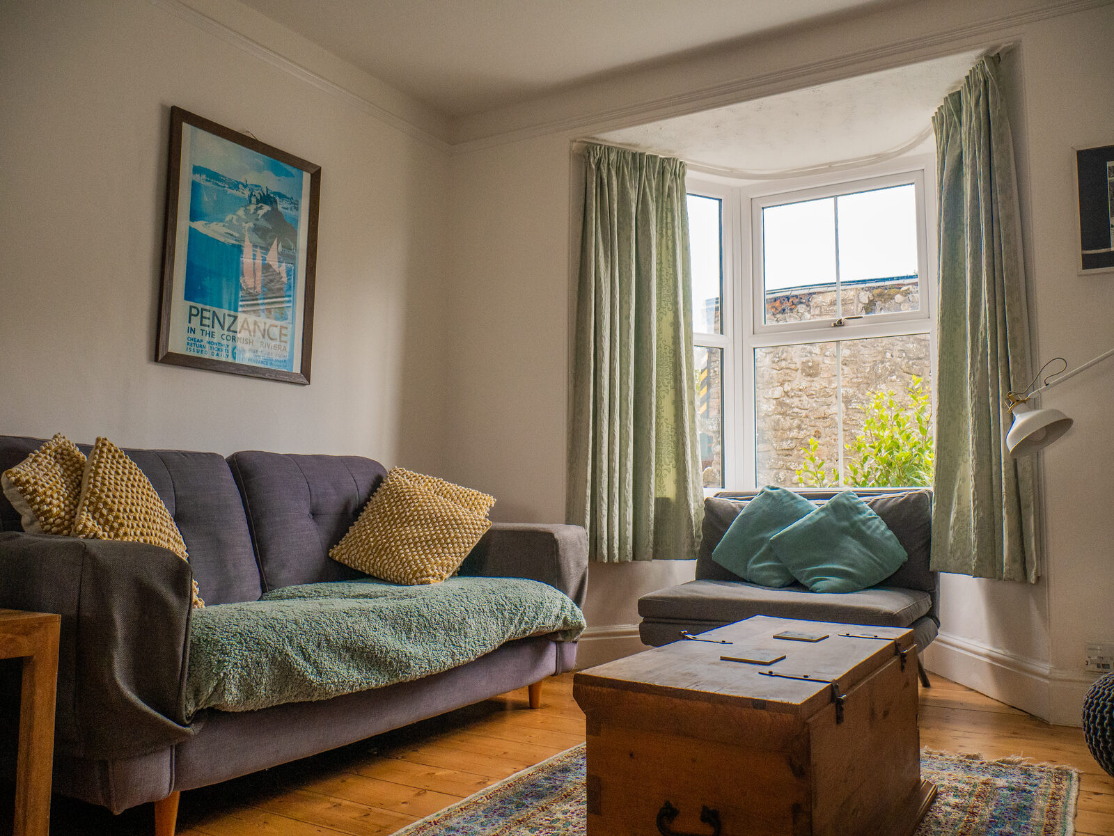 Bright sitting room with vintage Penzance print and comfy sofas